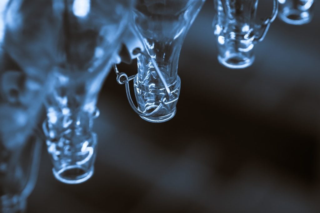 an image of clear glass beverage bottles in a manufacturing plant