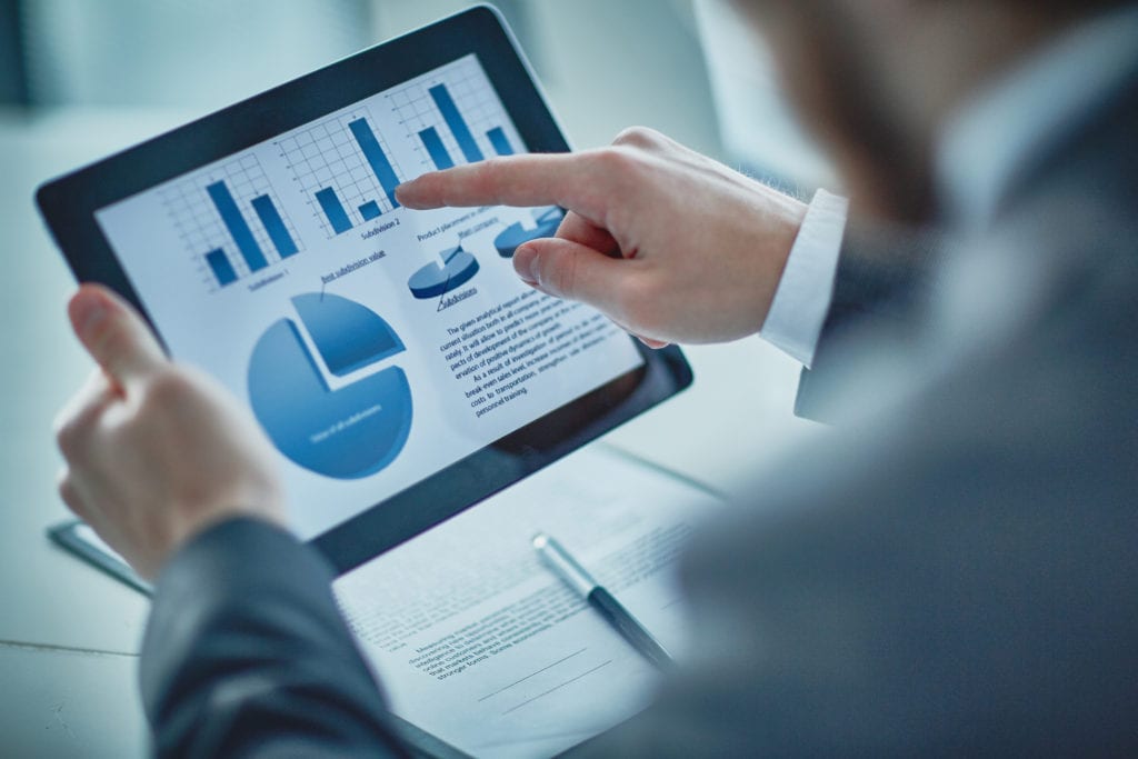 An image of an employee reviewing reports on a mobile tablet.