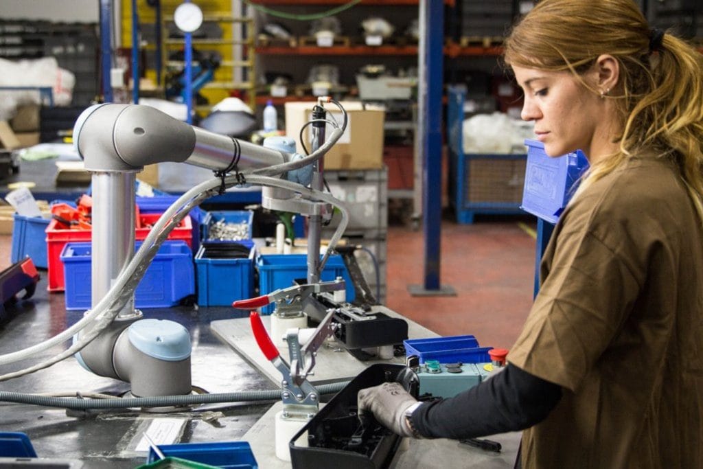 A picture of a worker and cobot working in manufacturing facility where collaborative robotics are in use