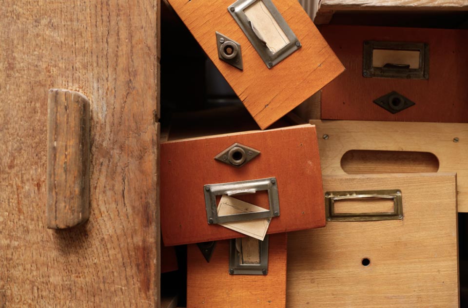 an image of disorganized wooden drawers.