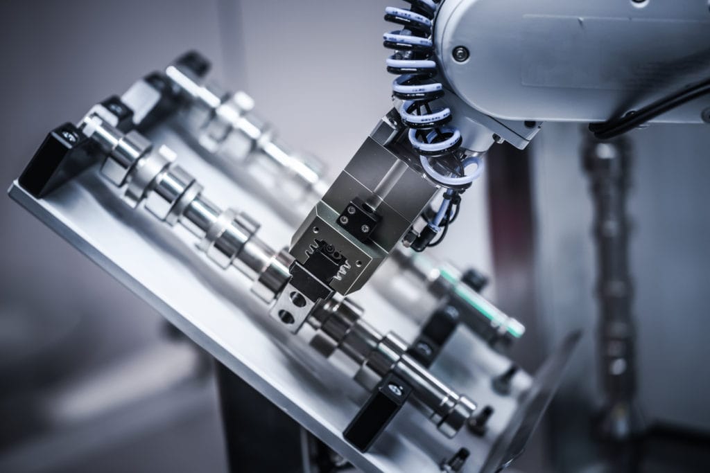 A photo of a robotic arm working on a factory floor.