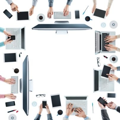 An image of a table of office workers using computers, tablets, and mobile devices around a table as part of IIoT connectivity.