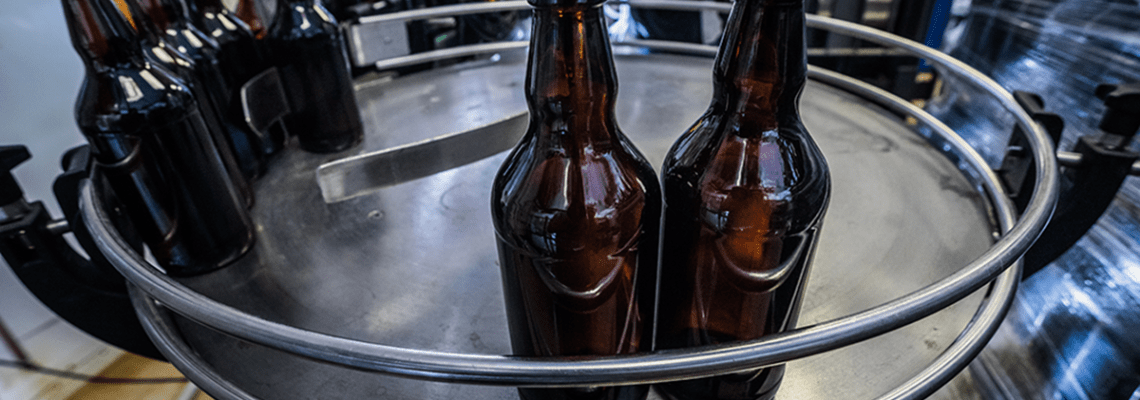 A photograph of bottle being manufactured before labelling and brand personalization