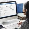 an image of an employee using enterprise resource planning software to track and schedule projects from her desk
