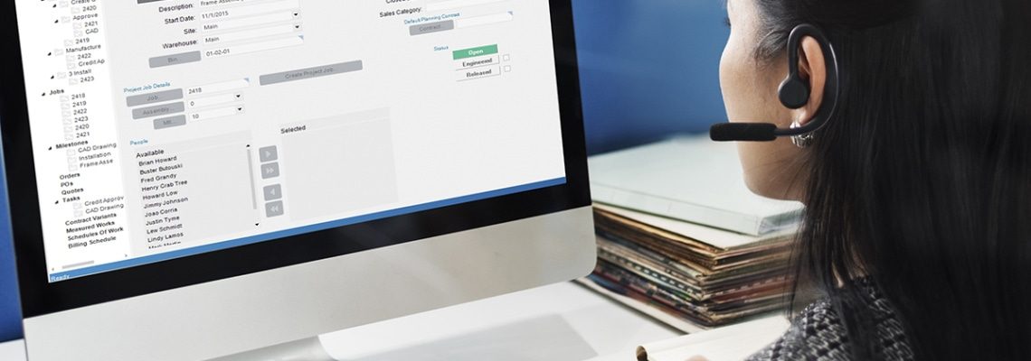 an image of an employee using enterprise resource planning software to track and schedule projects from her desk